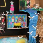 Detail of collage of landscape, city scape, and interior scenes, two-dimensional and three dimensional, installed on a black wall.