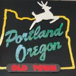 Detail of collage of landscape, city scape, and interior scenes, two-dimensional and three dimensional, installed on a black wall.