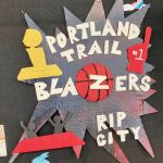 Detail of collage of landscape, city scape, and interior scenes, two-dimensional and three dimensional, installed on a black wall.