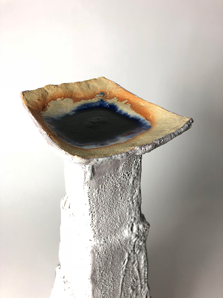 Flat orange and blue square on top of a white tower, ceramic