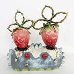 Image of two strawberries on a blue mantle made from ceramic