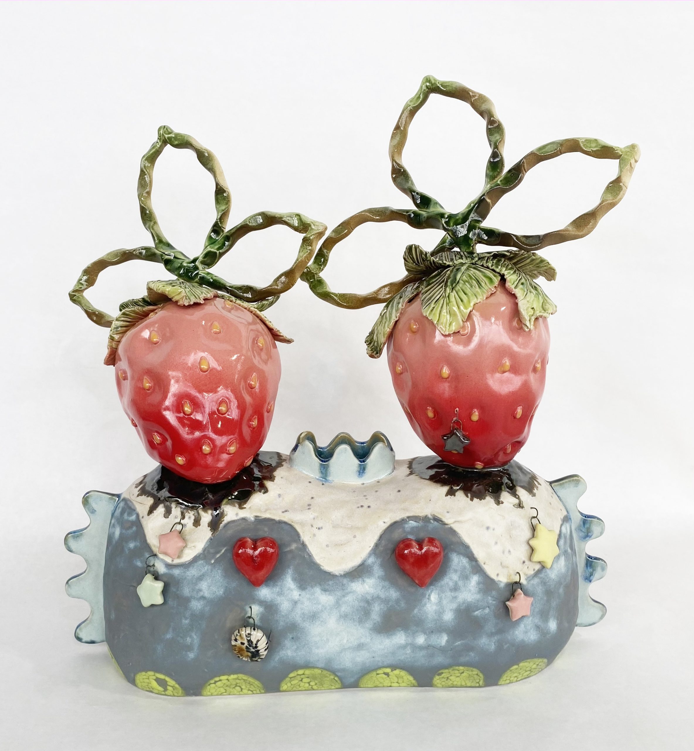 Image of two strawberries on a blue mantle made from ceramic