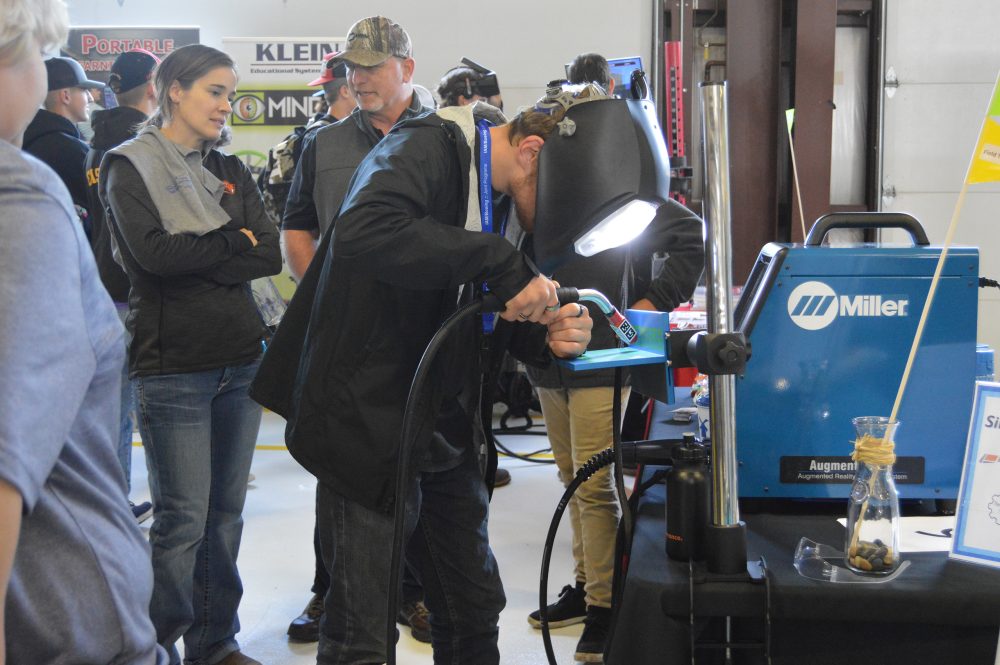 Student participating in welding demo.