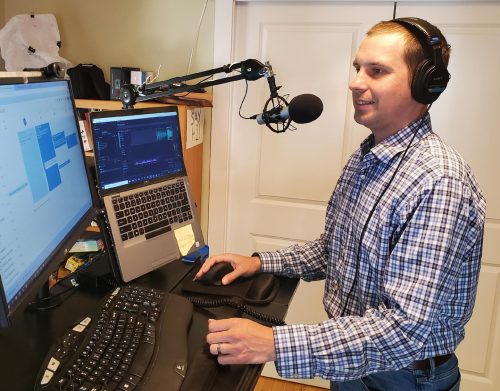 Man at a computer recording a podcast