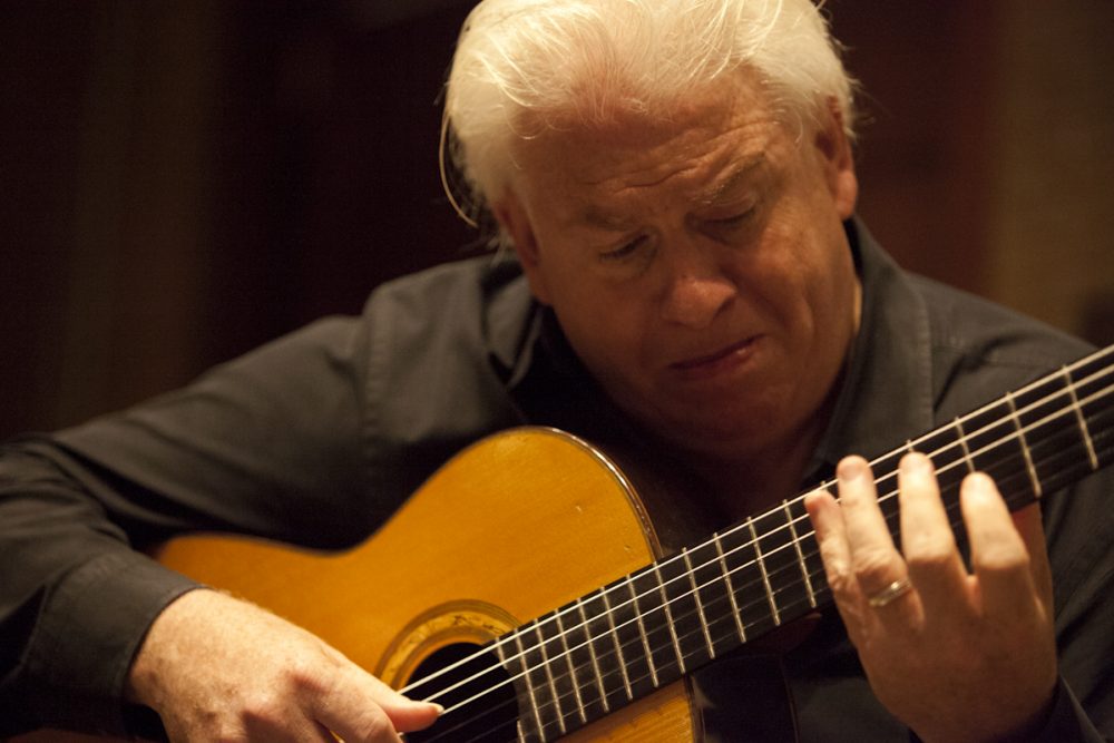 Photo of man playing a guitar