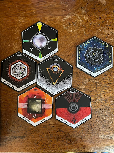 six tarot cards on a wooden desk