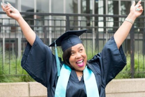 grad with arms raised in celebration