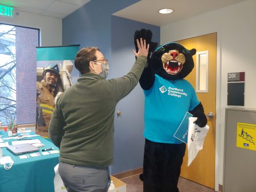 Poppie the Panther high fiving a new employee