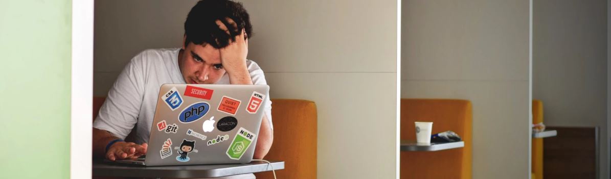 man at a computer struggling with what he is reading