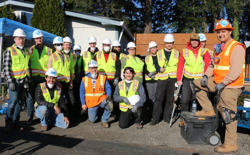 Trades class group photo in hardhats and vests.