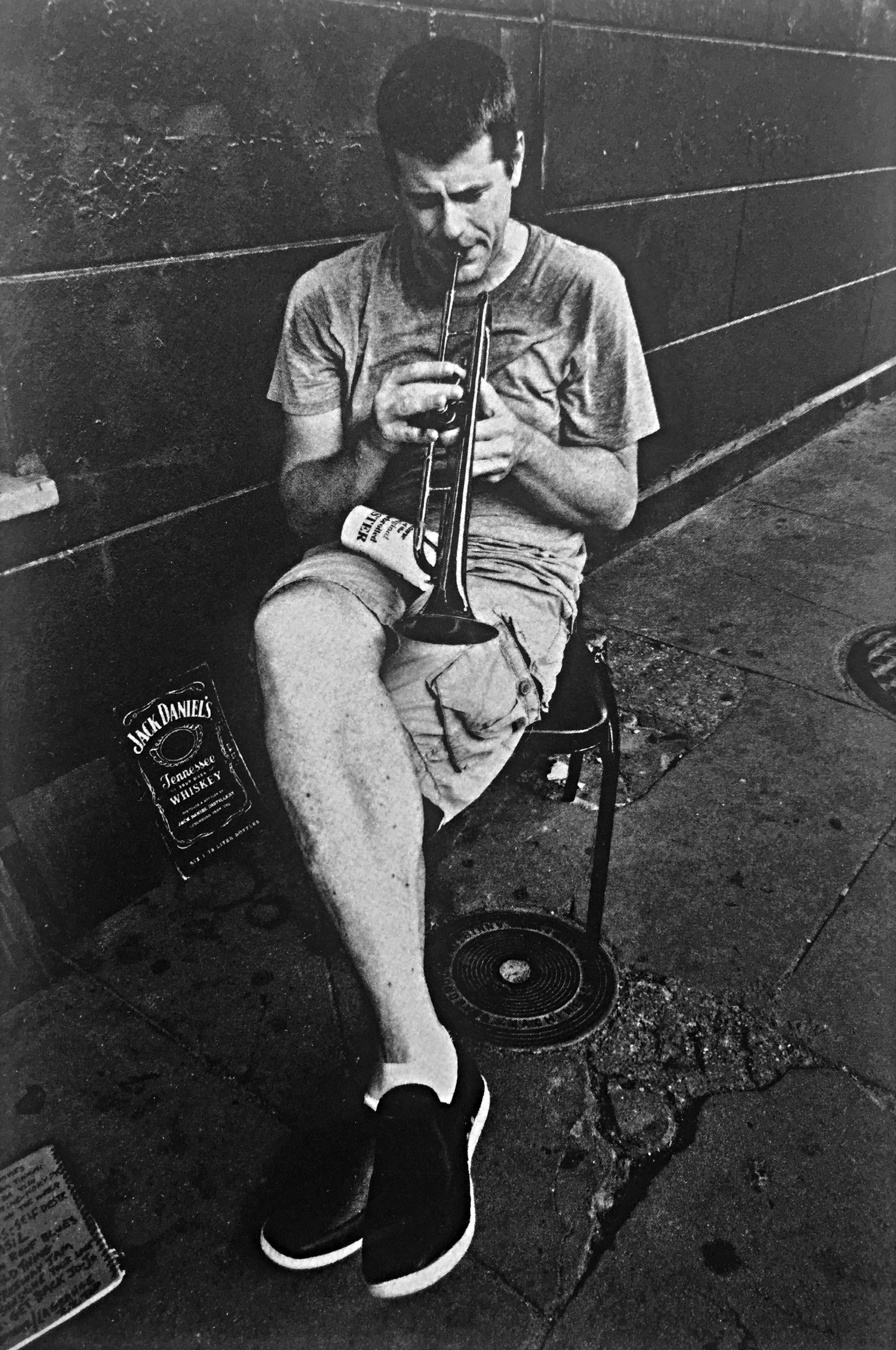 Man sitting on folding chair plays a trumpet