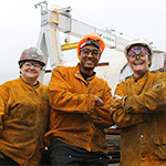 Group of welders with a huge crane
