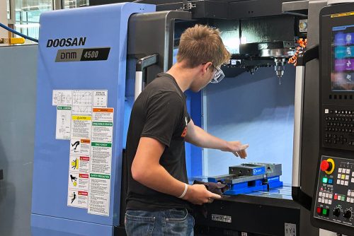 Student working with machining equipment