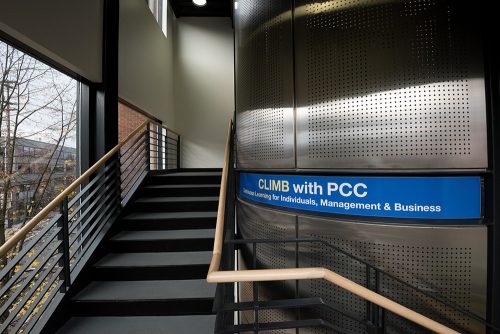 CLIMB interior staircase, with a sign reading "CLIMB with PCC: Continuous Learning for Individuals, Management, and Business"
