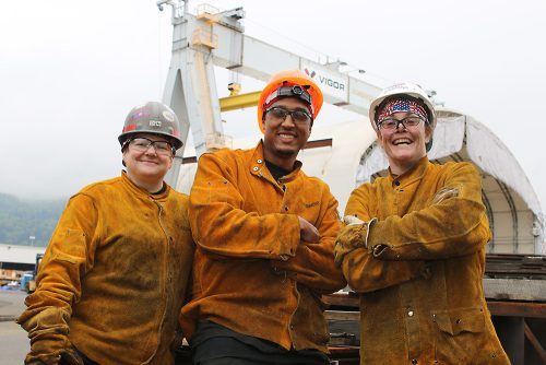 Maritime welding students in front of a ship