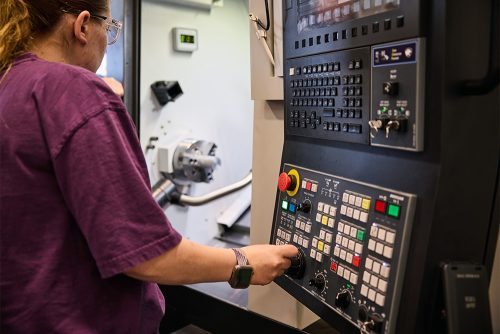 Machine Manufacturing student working at a control panel