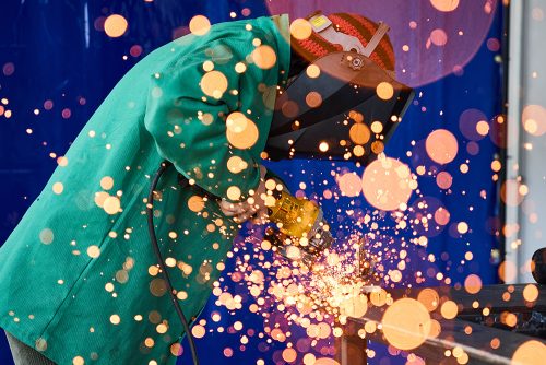 Welding student working with colorful sparks flying