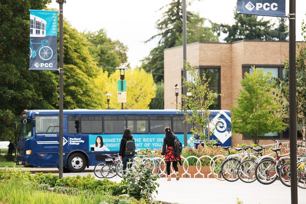Students walking towards a PCC shuttle past a row of bikes