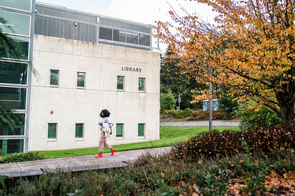 Student walking past the Library