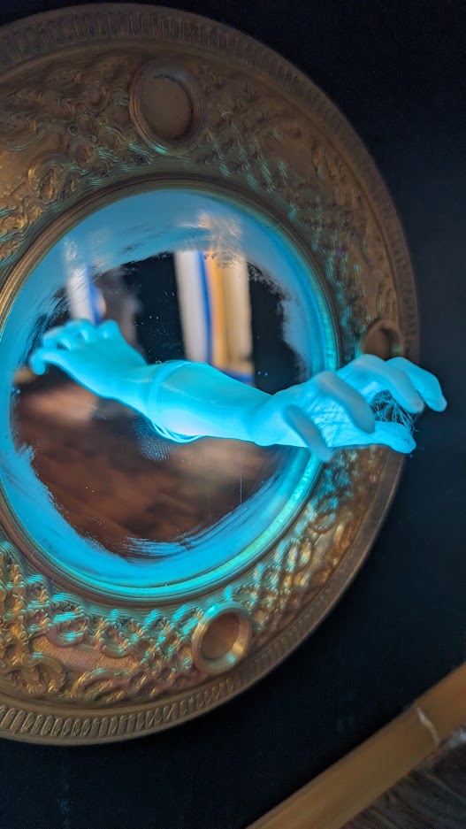 Glow in the dark hand coming out of the mirror in the Haunted Dollhouse