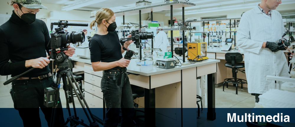 Marketing and Communications Division website header featuring the video capturing of a bioscience lab. Two camera operators are filming what's happening in the classroom. Banner reads Multimedia.