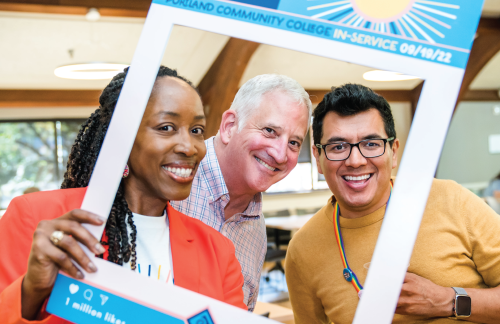 PCC In-Service event photo, featuring PCC President and staff members taking a photo with a rectangle image frame.