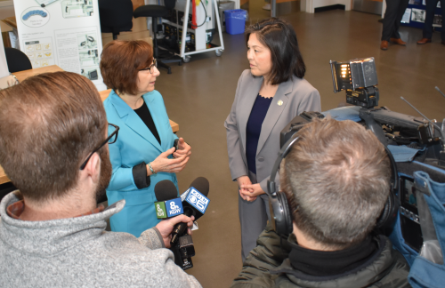 Photo featuring a news team interviewing U.S. Labor Secretary Julie Su (right) and Oregon Congresswoman Suzanne Bonamici.