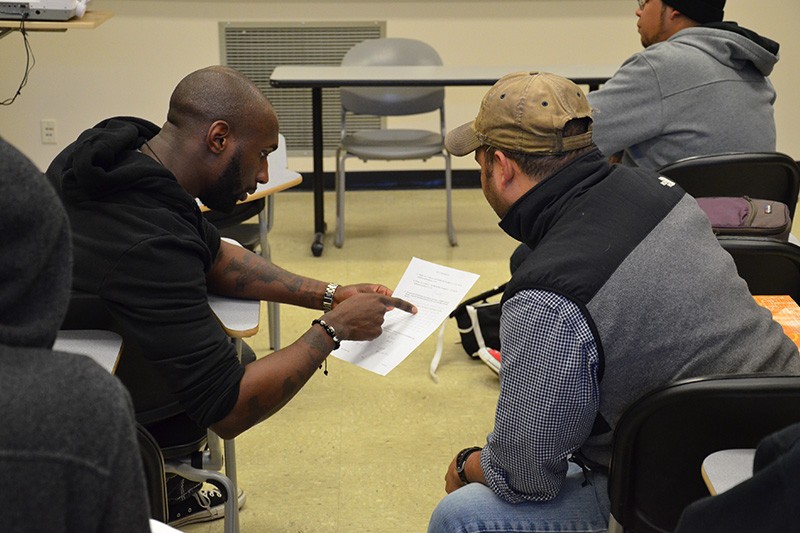 Students talking and pointing at a piece of paper between them