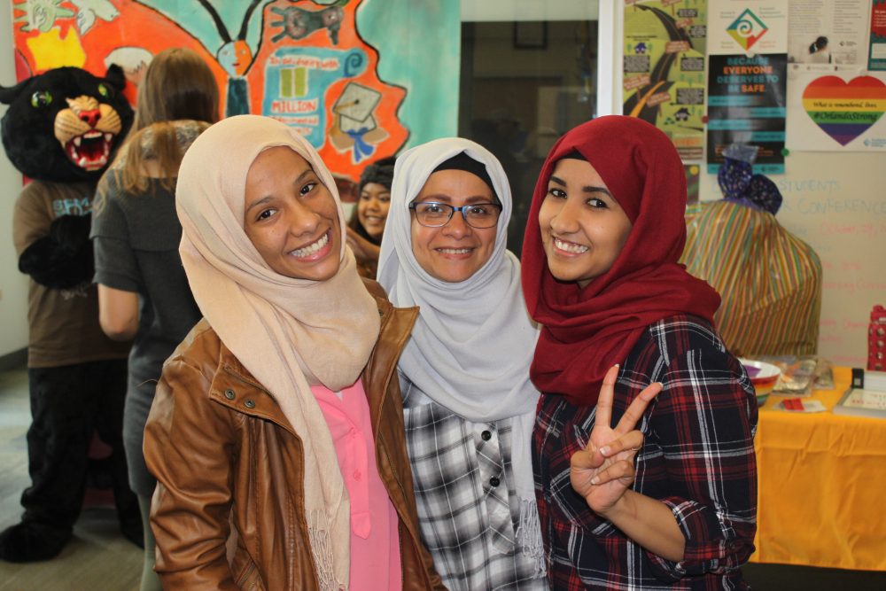 Three students standing together at an MC event