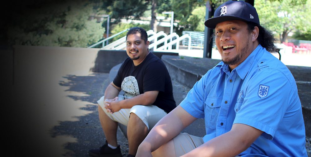 A student and staff member sitting on the steps outside the SY Performing Arts Center