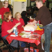 Tim Parsons, a second-year nursing student, demonstrates CPR techniques as interim nursing director Alisa Schneider (left) gives feedback. Holly Hererra (standing) and Karen Christensen (seated) – both second-year nursing students – observe.