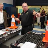 Russ Jones (right), Automotive Service Technology Program instructor, shows Congressman Kurt Schrader the Ford (right foreground) and the Honda Civic battery packs.