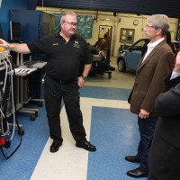 Jones shows Congressman Schrader the high voltage charger used in the school's program.