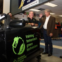 Jones (left) shows the Congressman PCC's Toyota Prius that students work on.