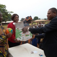 Isaac Sunday hands over his donation to school officials in Awing, Cameroon last fall.