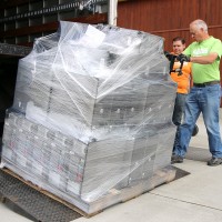Central Distribution Services personnel Drew Smith (green shirt) and Dennis Gonzalez unload the computers at Vernonia's new K-12 school.