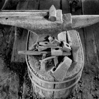 'Anvil and Hammer' from Loren Nelon's exhibit 'Portal to the Past,' featuring black and white photographs of a preserved blacksmith's shop from the 1960s.