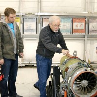 Aviation Maintenance Technology faculty Marshall Pryor (center) shows students, left to right, Edward Stravens, Michael Parkes and Jacob Rothgeb the new Williams International turbofan engine.