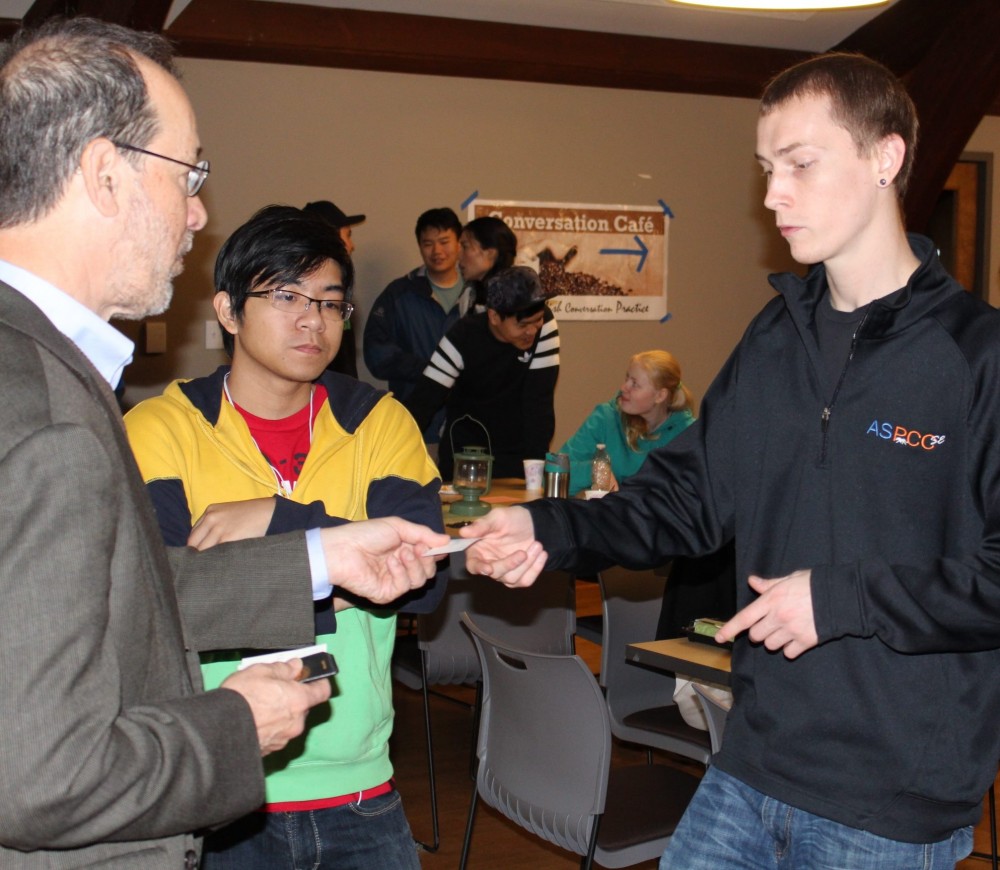Senator Dembrow hands his business card to ASPCC student leader Bo Koering after helping to lead the conversation during Friday's Conversation Cafe.