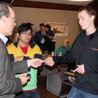Senator Dembrow hands his business card to ASPCC student leader Bo Koering after helping to lead the conversation during Friday's Conversation Cafe.
