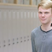 Gabriel and Ermine standing in a hallway in their high school