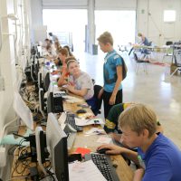 Held at a former auto shop behind Scappoose High School, Portland Community College faculty showed students how to design and print custom decals, etched glass, pop-up cards and charms that showcased their company’s logo