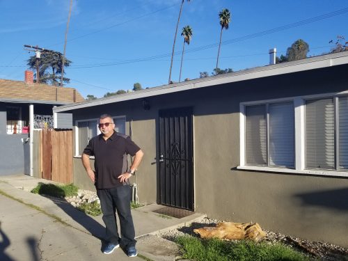 Villa standing outside his childhood home in East L.A. where he'd take a bus across town to attend Catholic school.