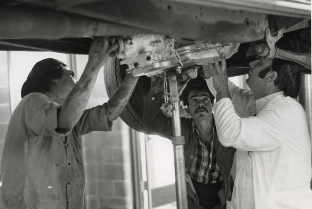 Guys checking out a car.