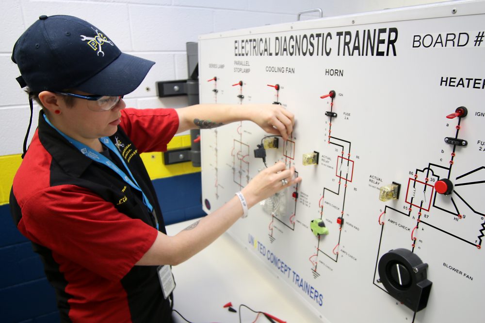 Boone works on an electrical diagnostic board used in auto training.