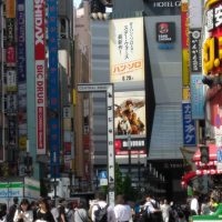 Photo of Godzilla over Toho theater and the busy crowd of Shinjuku.