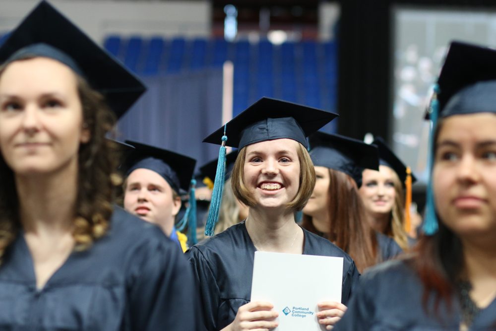 Happy graduate holds her degree.