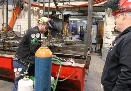 Tanner lights a torch while Matt watches.