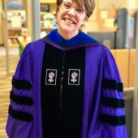 Dr. Jessica Howard poses in her regalia from NYU