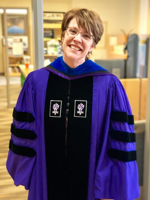 Dr. Jessica Howard poses in her regalia from NYU